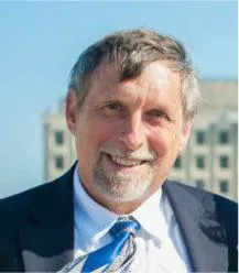 A man in suit and tie smiling for the camera.